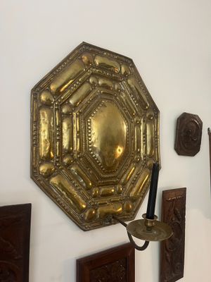 a wall with a mirror and a candle holder on it