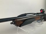 a close up of a rifle on a stand with a red dot on it