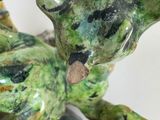 a statue of a frog that is sitting on a rock