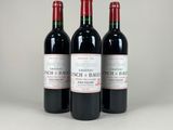 trois bouteilles de vin rouge posées côte à côte sur une table