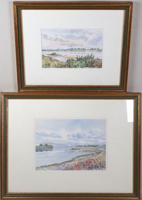 two framed watercolor paintings of a view of a beach and a body of water