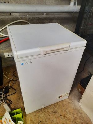 a small white refrigerator sitting on the floor in a room
