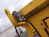 a close up of a yellow dump truck with a power cord attached to it