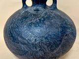 un vase bleu posé sur une table