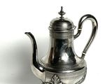 silver plated tea pot on stand on white surface with white background