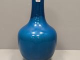 a blue vase that is sitting on a white table