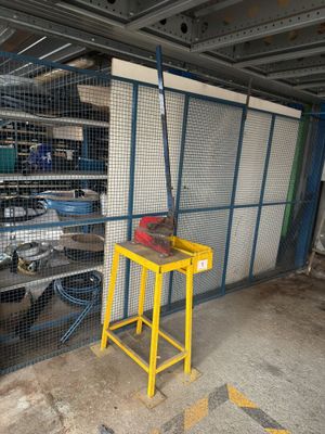 a small yellow table in a garage with a yellow stool