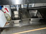 three metal pans sitting on a stainless steel counter