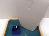 necklace, ring, and ring box on display in a display case