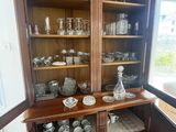 a china cabinet with a lot of glassware on it