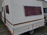 a small white trailer parked in front of a building