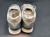 a pair of new balance shoes sitting on the floor