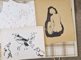 une pile de feuilles couvertes de dessins, posée par terre