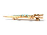gold alligator brooch with turquoise stones on a white background