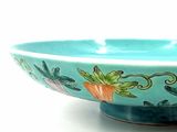 a blue bowl with a design of carrots and leaves on it