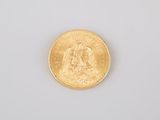 a close up of a gold coin on a white surface