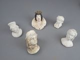 five busts of different people on a gray surface