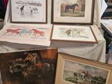 plusieurs reproductions, encadrées ou non, représentant des chevaux, posées sur une table