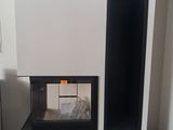une cheminée noire et blanche dans une pièce avec du parquet