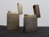 two lighters sitting on top of a black table next to each other