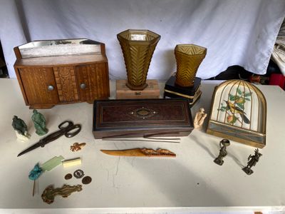 une table sur laquelle se trouvent divers objets, notamment une horloge, des vases et d'autres objets