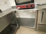 plan de travail en acier inoxydable dans une cuisine professionnelle équipée d'un micro-ondes et d'un four