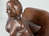 statue of a woman sitting on a bench with a basket on her lap