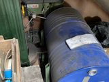 a large blue barrel sitting next to a pile of wooden crates