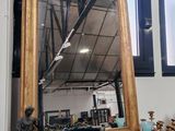 un miroir posé sur une étagère dans une pièce, près d'une fenêtre