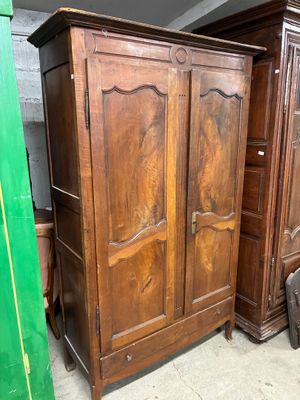 une armoire en bois dans une pièce dont la porte est verte