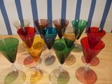 many different colored wine glasses sitting on a table