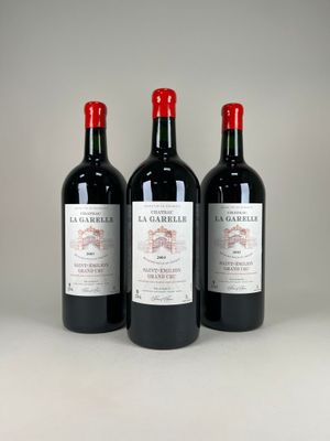 three bottles of red wine sitting next to each other on a table