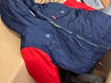 a pile of clothes in a box with a jacket on it