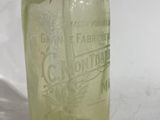 a green glass bottle with a black cap on it