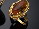two rings with different colored stones on a black surface