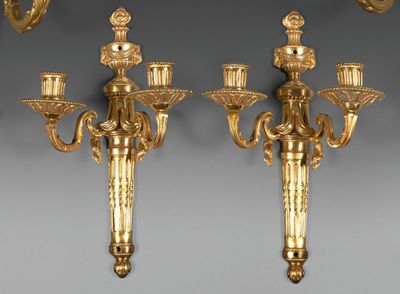 pair of antique brass wall sconces with candles on each of them
