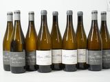 six bouteilles de vin sont alignées sur une surface blanche