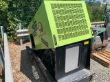 a green machine that is sitting on the side of the road