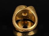 an image of a gold ring sitting on top of a black surface