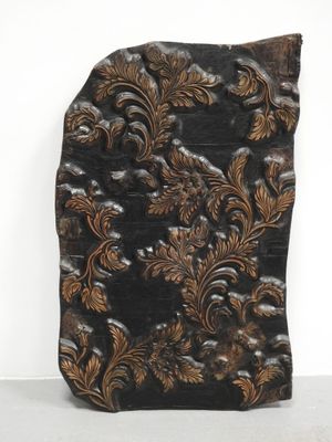une image représentant une plaque en bois ornée d'un motif floral