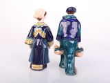 two figurines of a man and a woman standing next to each other
