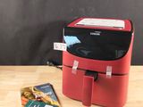 une petite boîte rouge avec un magazine posé sur la table à côté