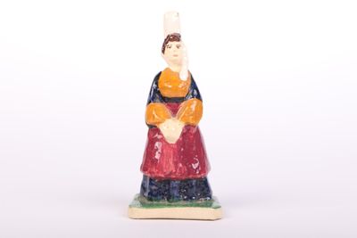 une petite figurine de femme en robe rouge et bleue