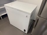 a small white refrigerator in the corner of a kitchen