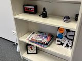 a white book shelf with various items on top of it