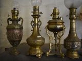 a lot of antique brass vases and lamps on a table