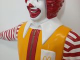 statue of ronald the clown in a red wig and striped shirt