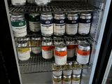 many cans of paint on a shelf in a refrigerator