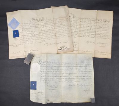 a group of three old papers with blue ink on them