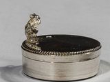 a small silver box with a bear sitting on top of it